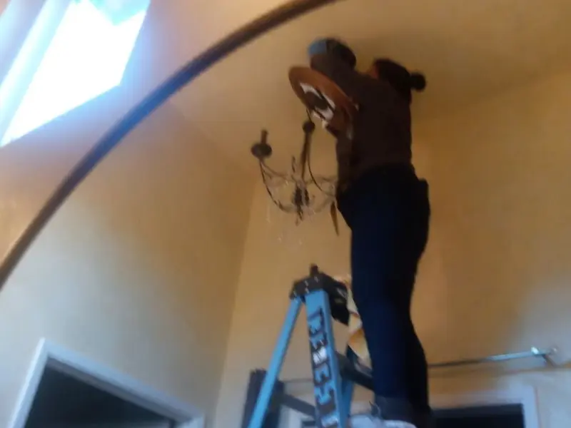 Electrician installing a chandelier in a Clearwater residence